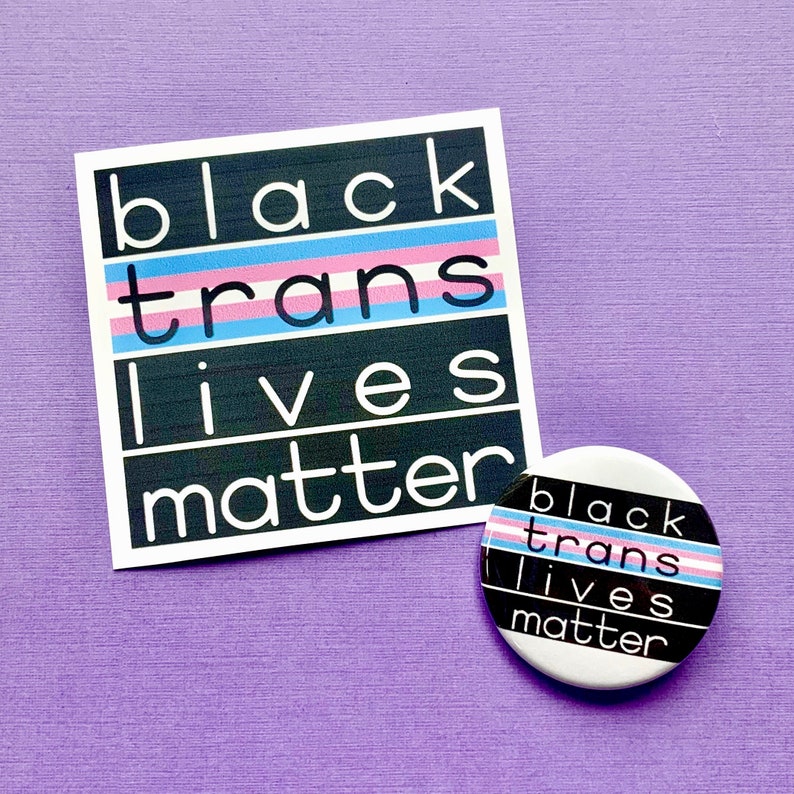 Puede incluir: Bot&oacute;n blanco y negro con el texto "black trans lives matter" en negro con un patr&oacute;n de rayas rosa, azul y blanco.