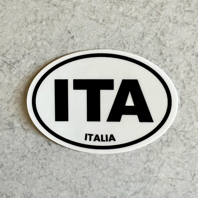 May include: White oval sticker with black text that reads "ITA" and "ITALIA".