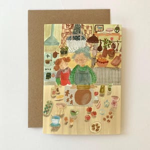 Pode incluir: Ilustração em aquarela de um cartão com uma cena de cozinha com duas pessoas a cozinhar. O cartão mostra uma mulher e uma criança a estender massa, com vários utensílios de pastelaria e biscoitos de gengibre na mesa.
