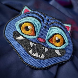 Op de afbeelding: Een witte keramische mok met een zwarte handgreep en de tekst "But First, Coffee" in een vetgedrukte, zwarte letter. De mok staat tegen een vage achtergrond, wat een gezellige setting suggereert.