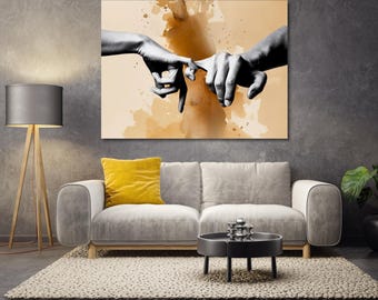 May include: A large canvas art print depicting two hands with index fingers nearly touching. The artwork is in grayscale with a sepia-toned background. The print hangs above a gray sofa with a yellow pillow.