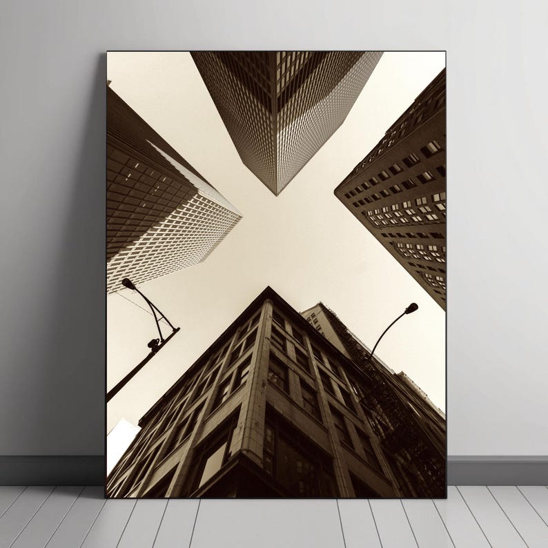 May include: A black and white photograph of a city skyline with tall buildings reaching up towards the sky. The buildings are seen from a low angle, giving the impression of looking up at them.