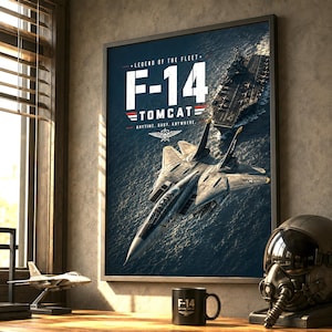 Może przedstawiać: Oprawiony plakat ścienny przedstawiający myśliwiec F-14 Tomcat lecący nad lotniskowcem na morzu. Tekst brzmi LEGEND OF THE FLEET F-14 TOMCAT ANYTIME. BABY. ANYWHERE. Obraz zawiera mały model samolotu oraz czarny kubek z napisem F-14.