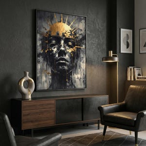 Könnte beinhalten: Ein gerahmtes abstraktes Kunstwerk mit einem Schwarz-Weiß-Porträt mit goldenen Akzenten. Das Kunstwerk zeigt ein menschliches Gesicht mit geschlossenen Augen und ein goldenes Sonnenstrahlen-Design auf dem Kopf. Das Stück wird in einem modernen Wohnzimmer gezeigt.