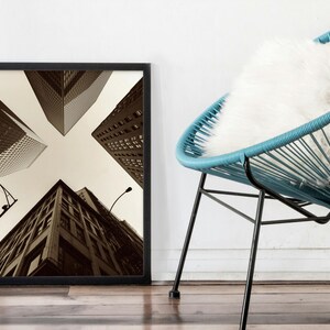 May include: Black and white framed photograph of a city skyline with tall buildings viewed from below. The buildings are arranged in a cross pattern.
