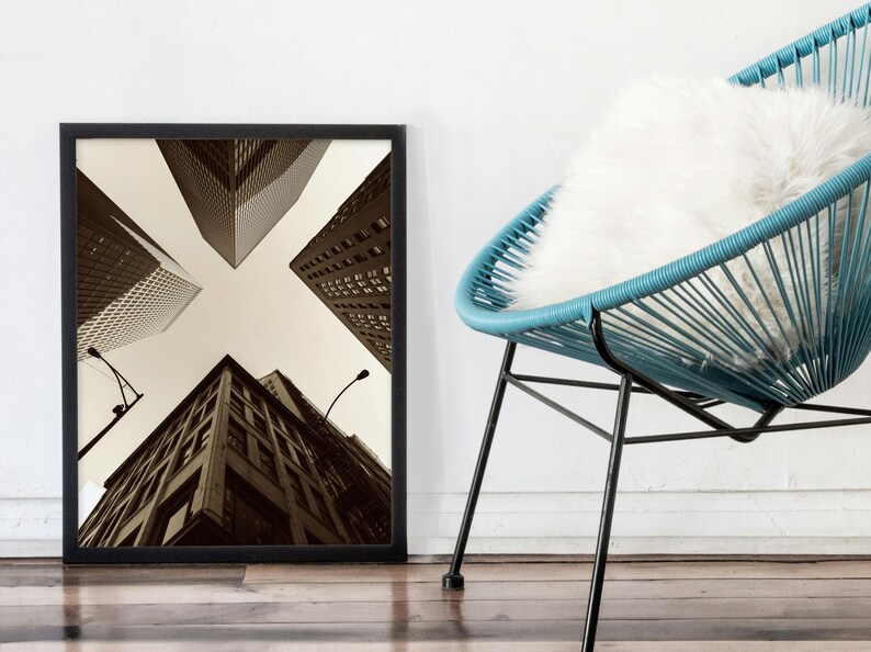 May include: Black and white framed photograph of a city skyline with tall buildings viewed from below. The buildings are arranged in a cross pattern.