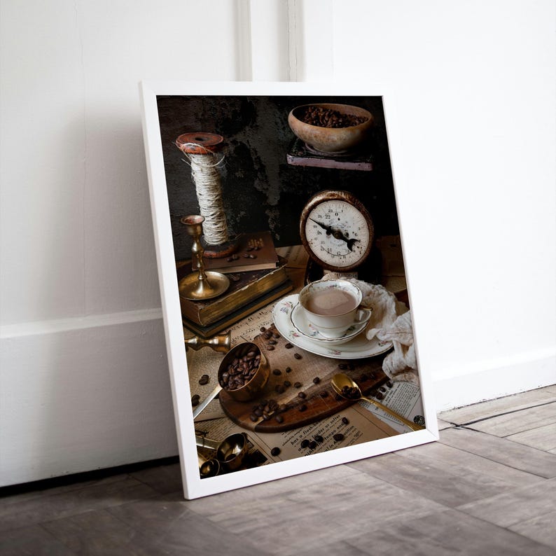 K&ouml;nnte beinhalten: Ein Stillleben mit einer Tasse Kaffee, Kaffeebohnen, einer Waage, einer Garnrolle, einem Kerzenhalter und einem Buch. Das Bild ist auf einem rustikalen Hintergrund mit Vintage-&Auml;sthetik platziert.