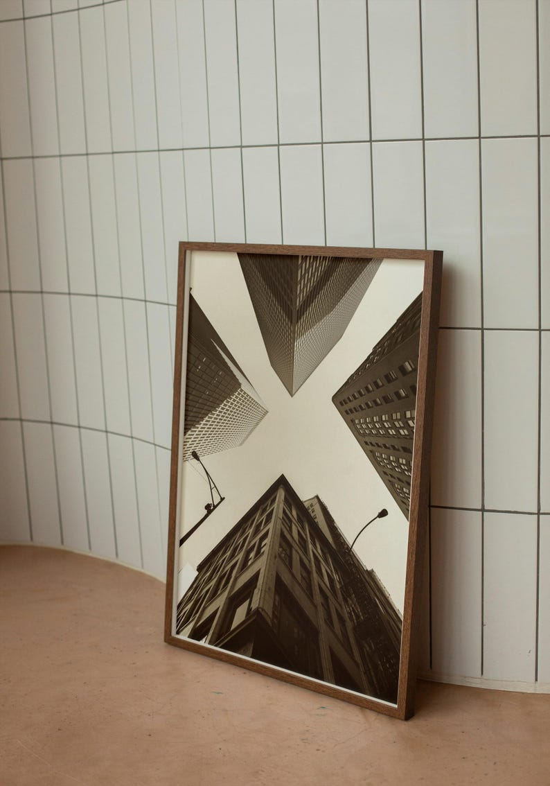 May include: A framed black and white photograph of a city skyline with buildings reaching up towards the sky.