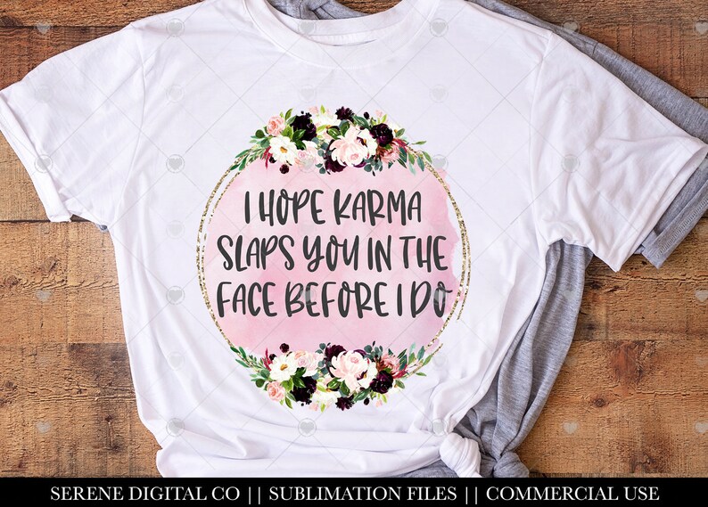 May include: White t-shirt with a pink watercolor circle and gold glitter border. The circle has the text "I hope karma slaps you in the face before I do". The circle is surrounded by a floral wreath with pink, white, and burgundy flowers.