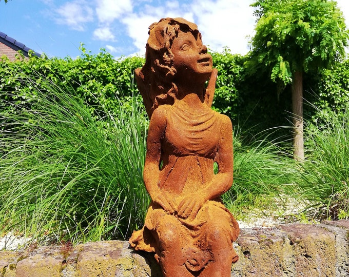 Garden sculpture of a sitting fairy - romantic garden design