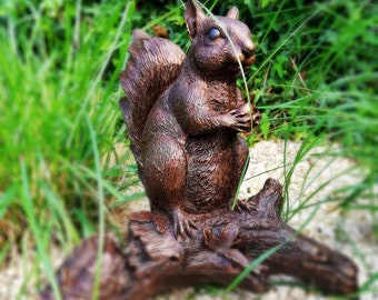 Statue en bronze d’un écureuil sur une souche