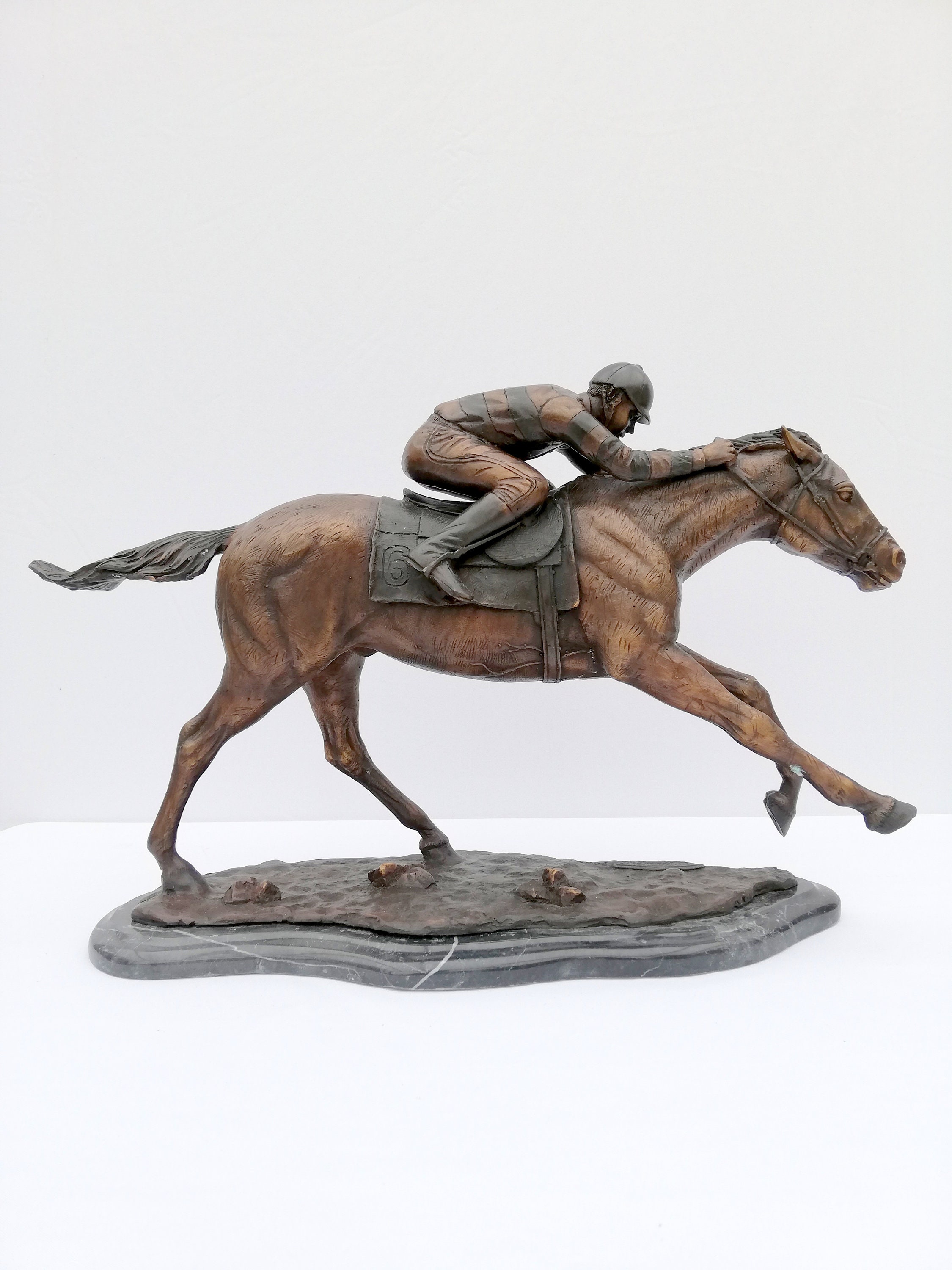 Bronze sculpture of a jockey on his racing horse