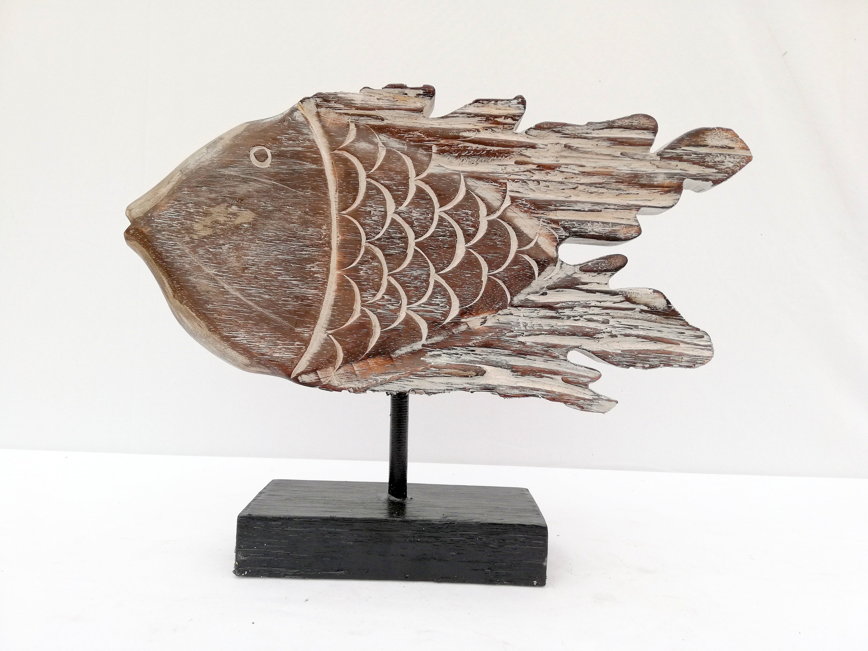A wooden fish sculpture on stand