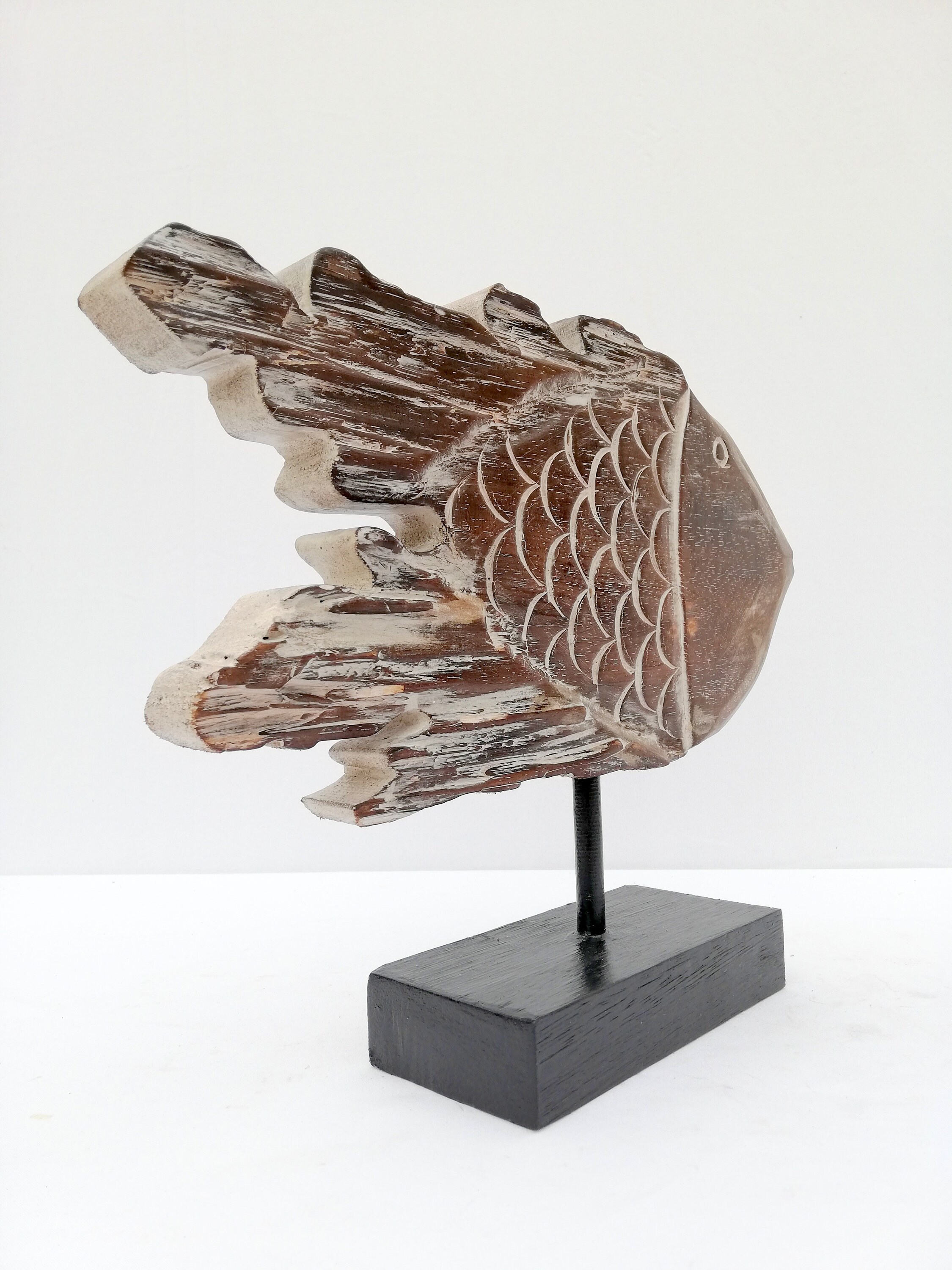A wooden fish sculpture on stand