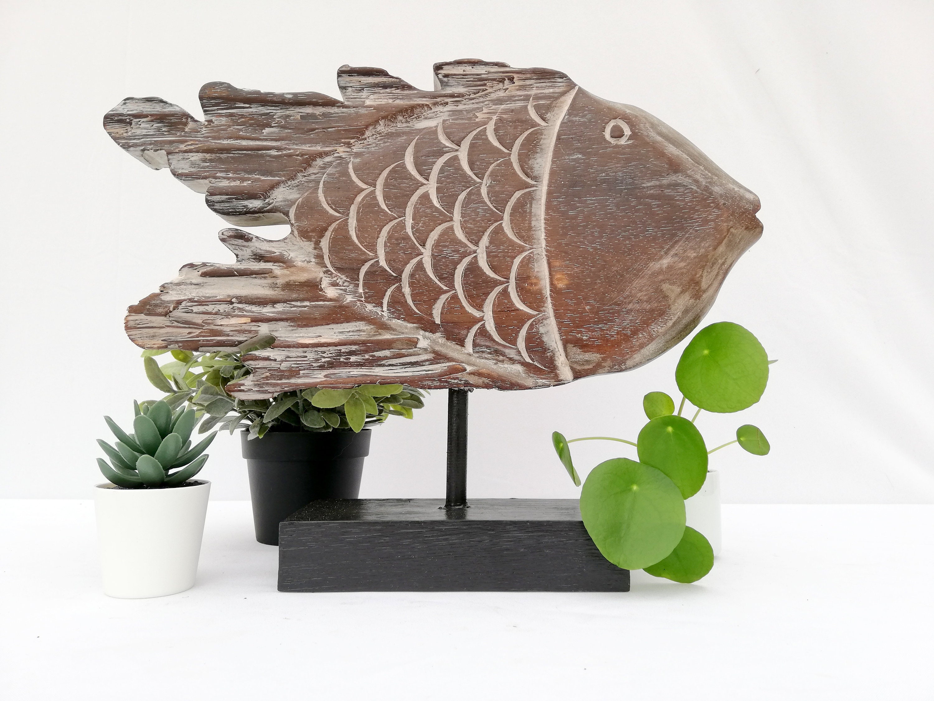 A wooden fish sculpture on stand