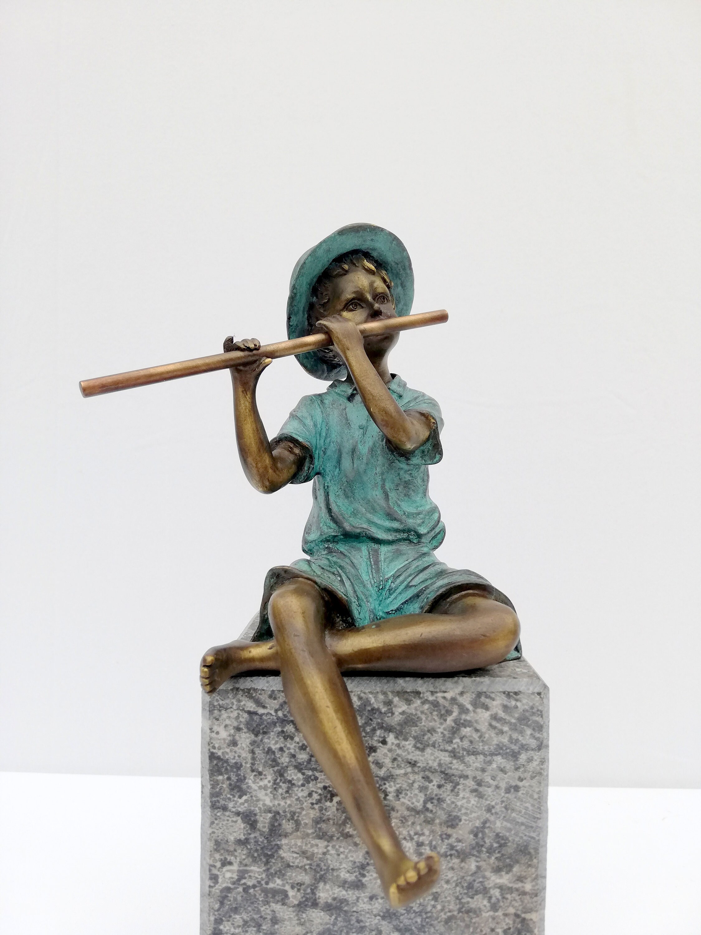 Bronze boy figure playing the flute