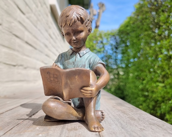 Ornements de jardin un garçon lit un livre -  France