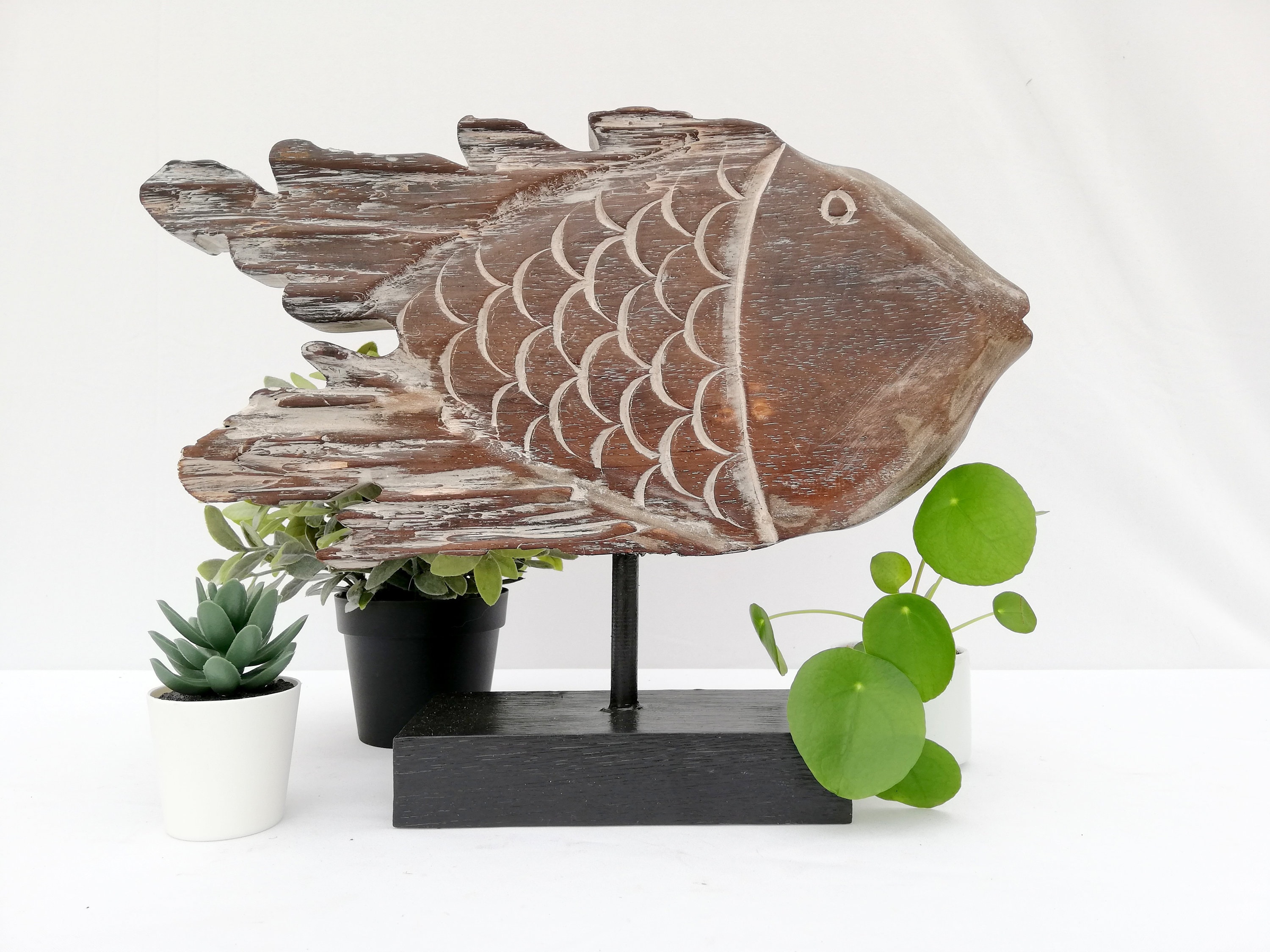 A wooden fish sculpture on stand