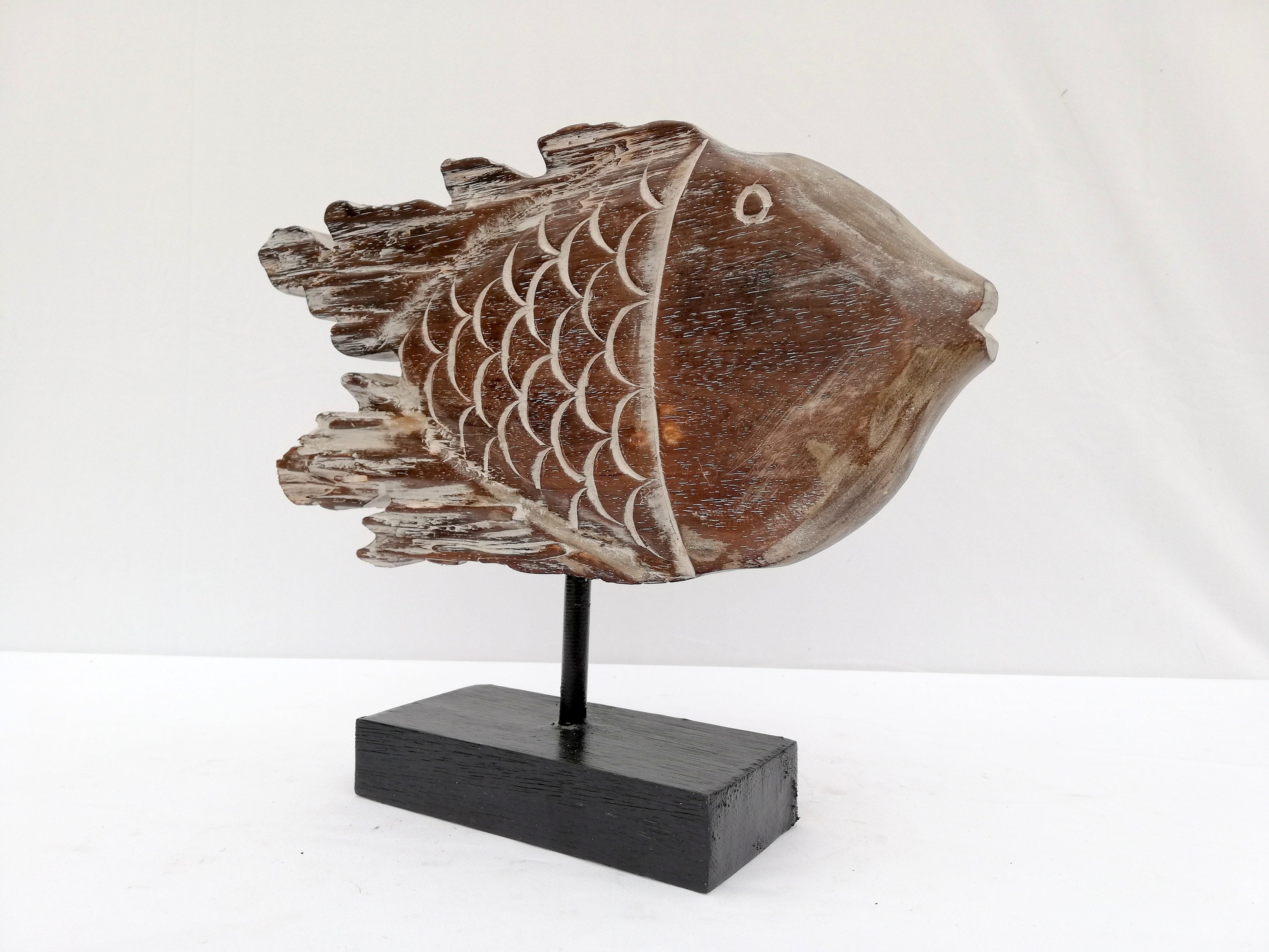 A wooden fish sculpture on stand