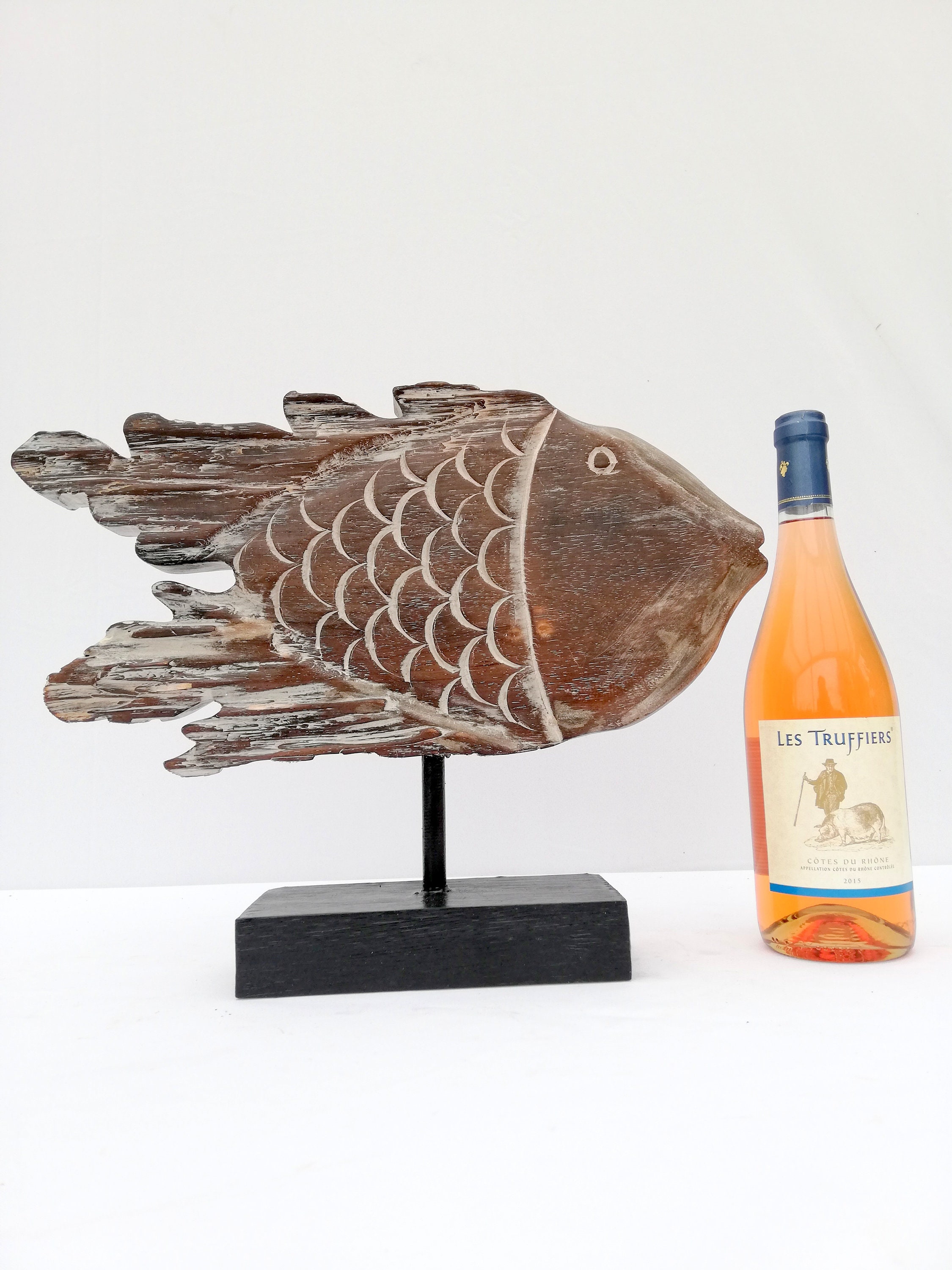 A wooden fish sculpture on stand