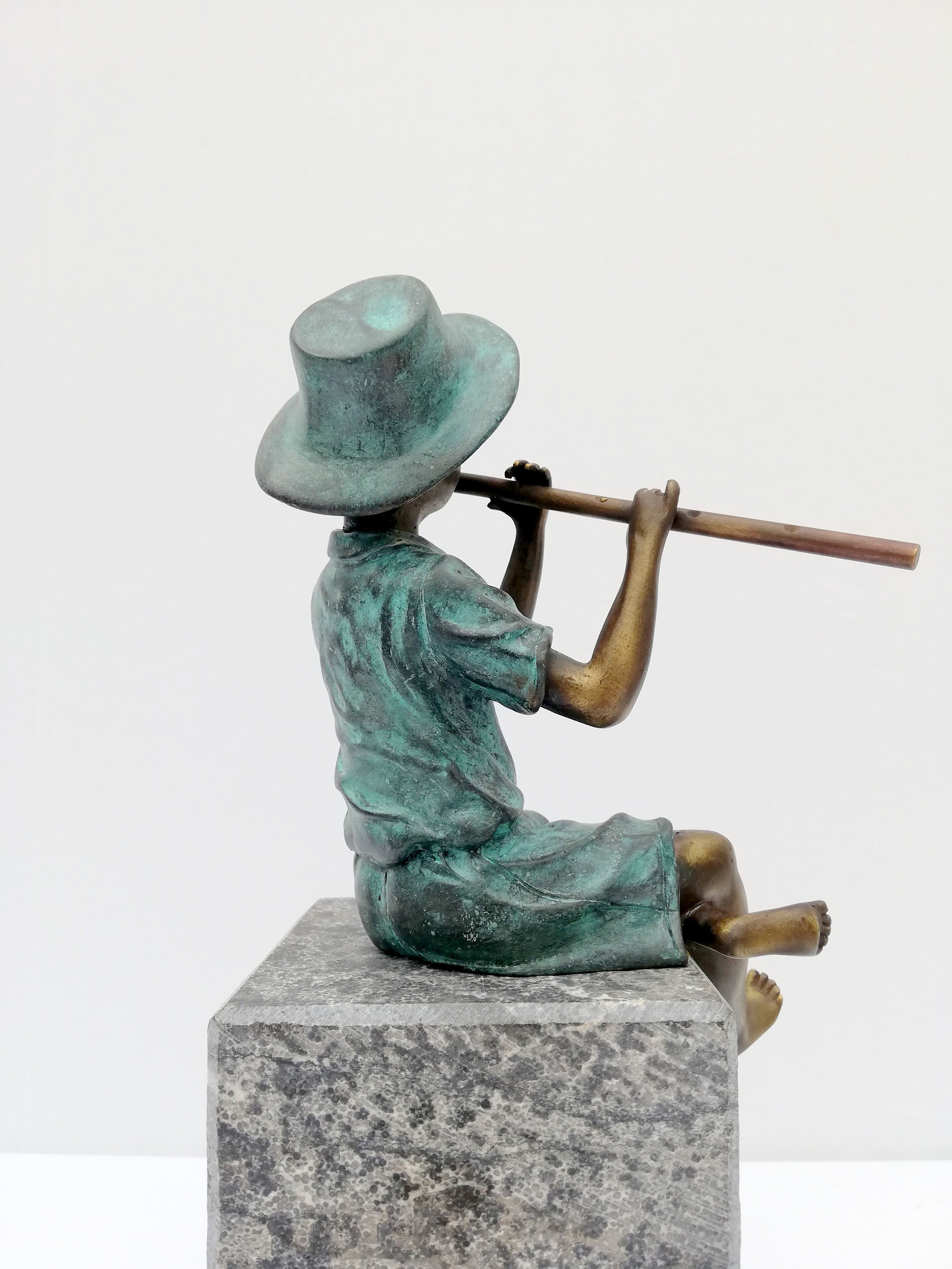 Bronze boy figure playing the flute