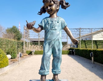 Petite fille avec oiseau à la main - Sculpture de jardin en bronze