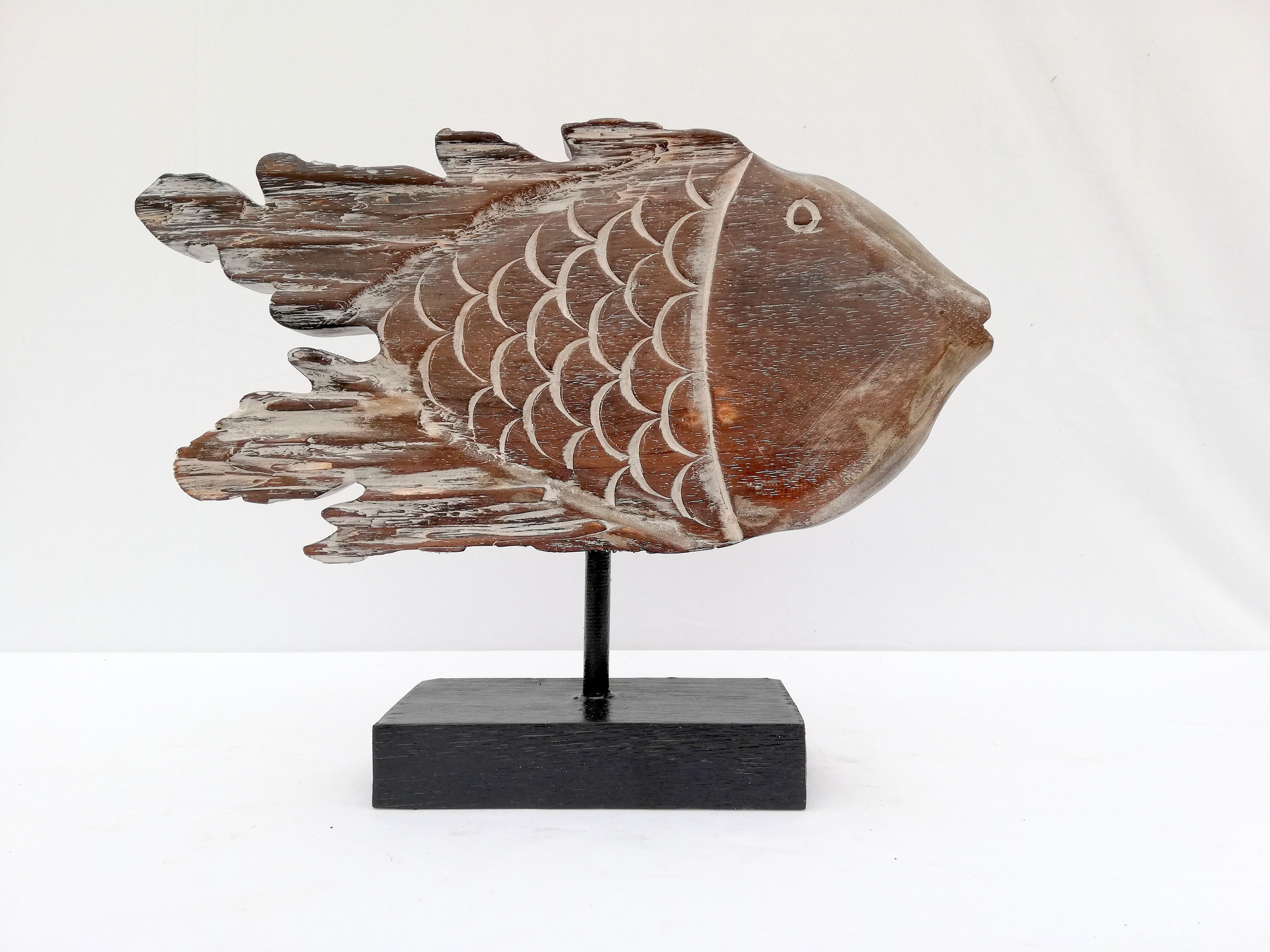 A wooden fish sculpture on stand