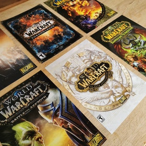 May include: A collection of World of Warcraft expansion pack covers. The covers feature different artwork and text, including "Shadowlands", "Battle for Azeroth", "Burning Crusade", and "15 Year Anniversary".