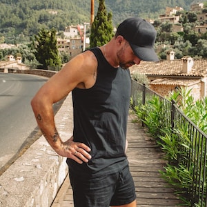 Puede incluir: Una gorra de b&eacute;isbol negra, una camiseta sin mangas negra y unos pantalones cortos negros con cintura de cord&oacute;n. El conjunto presenta una paleta de colores totalmente negra, con un dise&ntilde;o sencillo de cuello redondo y un corte est&aacute;ndar en el pantal&oacute;n.