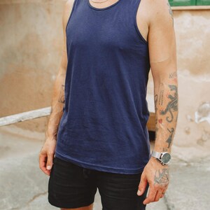 Puede incluir: Una camiseta sin mangas de color azul marino s&oacute;lido con cuello redondo y tirantes anchos, combinada con pantalones cortos negros. La camiseta presenta un dise&ntilde;o sencillo sin estampados con un dobladillo recto que cae a la cadera, de tela lisa.
