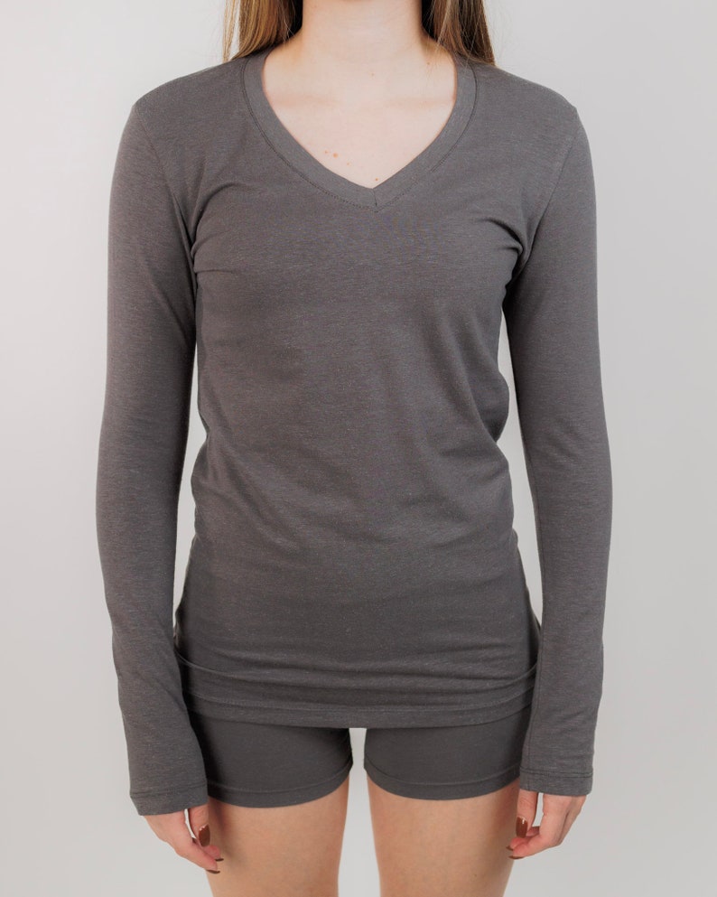 May include: A long-sleeved, charcoal gray V-neck shirt with a relaxed fit.