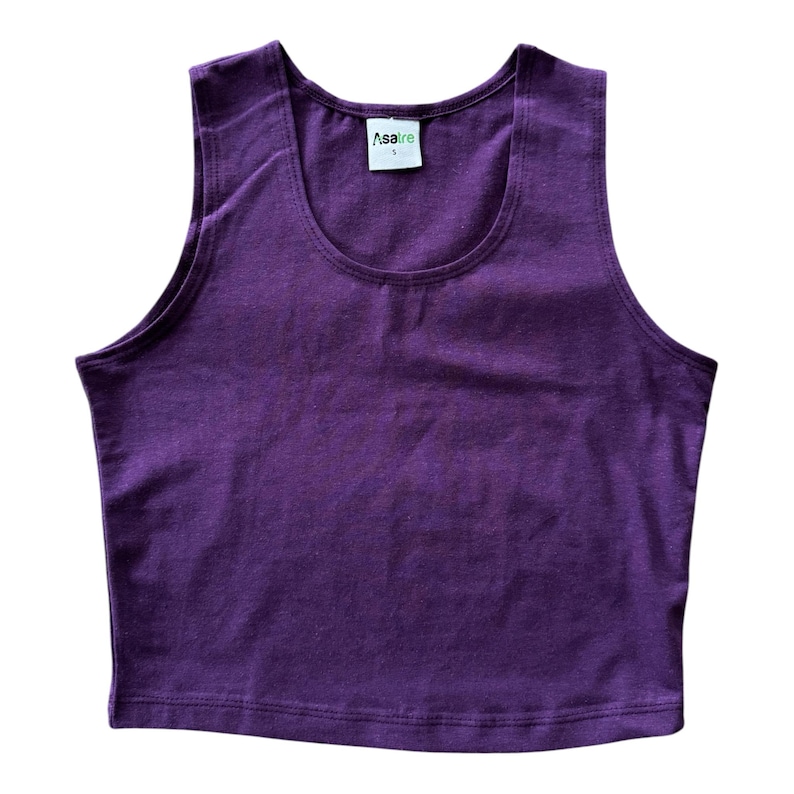 May include: A solid deep purple sleeveless crop top with a scoop neckline. The garment features a white interior neck label with the brand name Asatre printed in black text and the size S printed below it in a smaller font size.