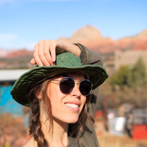 Woman wearing an olive hemp sun hat with sun glasses on.