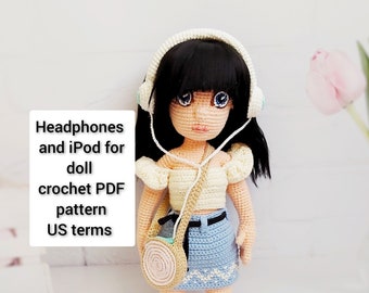 Könnte beinhalten: Häkelpuppe mit weißem Oberteil, blauem Rock und Kopfhörern. Die Puppe hält eine kleine gehäkelte Tasche. Das Bild enthält den Text "Headphones and iPod for doll crochet PDF pattern US terms".