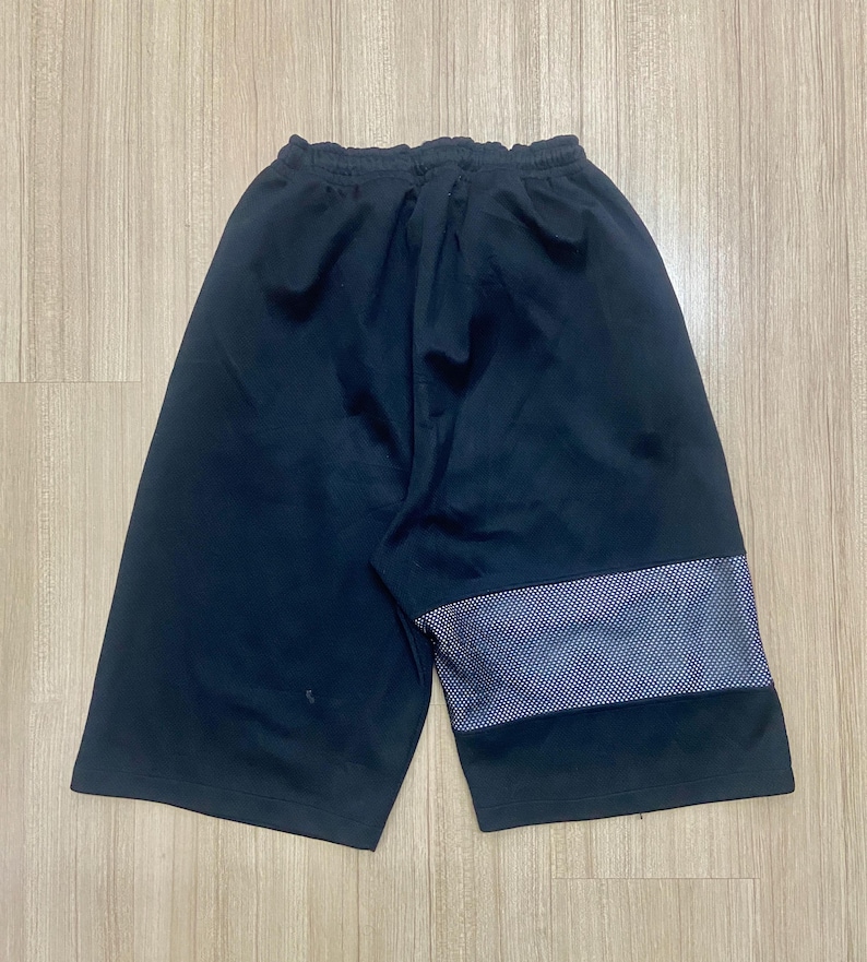 Puede incluir: Pantalones cortos deportivos negros con cintura con cord&oacute;n. Los pantalones cortos tienen un panel de malla en la parte inferior de la pierna. Los pantalones cortos est&aacute;n hechos de un material suave y c&oacute;modo.