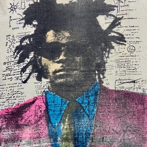 K&ouml;nnte beinhalten: Ein Schwarzwei&szlig;portr&auml;t von Malcolm X vor einem rosafarbenen und blauen Hintergrund mit Mustern. Der Hintergrund enth&auml;lt handschriftlichen Text und Zeichnungen.