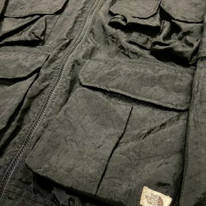 Peut inclure: Veste de bombardier noire avec plusieurs poches avant et une fermeture &eacute;clair. La veste pr&eacute;sente un col et des poignets c&ocirc;tel&eacute;s, ainsi qu'un petit &eacute;cusson logo sur le devant. La veste est en tissu textur&eacute;.