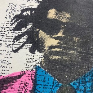 K&ouml;nnte beinhalten: Ein Vintage-T-Shirt in Wei&szlig; mit einem Schwarzwei&szlig;-Portr&auml;t einer Person. Das Portr&auml;t ist von einer bunten Karte mit handschriftlichem Text und Pfeilen umgeben. Der Text enth&auml;lt "100.", "EROK", "(FOSSILS)", "EGO", "A LIAR", "UNINABITED", "LEX VI VEMUS", "PGIA X", "HIVE SACK OF T", "T (SHAMONS", "G", "FRANCIS", "THE", "HO", "FIRSTO LOUIS", "ELITA", "22", "ETH OF", "MA", "DOWN", "A", "10000", "SHUTOUN SHELLS", "12 OLIVE DIL", "JOSILY", "JOSIE", "JOSEY", "TENS", "STAL", "M", "PET", "M", "R", "5", "ZARY".