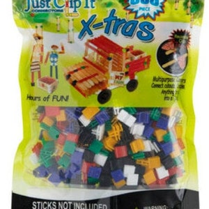 May include: A bag of 500 colorful plastic connectors for building toys. The bag is yellow and black with the words "Just Clip It X-tras" printed on it. The connectors are in various colors, including red, blue, green, yellow, and white.