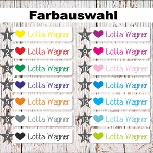 May include: A set of 14 iron-on labels with a white background and a black star in the top left corner. Each label has a different coloured heart in the top right corner and the text "Lotta Wagner" in black. The colours of the hearts are yellow, red, green, blue, orange, grey, black, purple, pink, light blue, dark blue, turquoise, and green.
