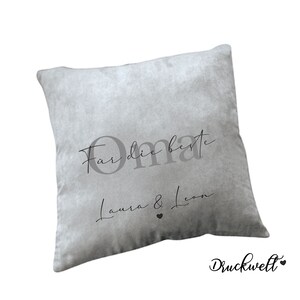 May include: Grey throw pillow with the text "For die beste Oma Laura & Leon" in black script font.