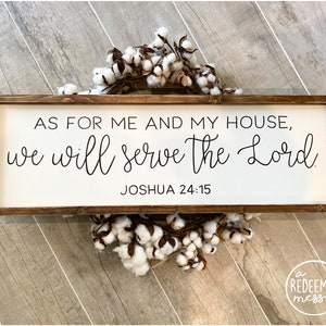 May include: A white wooden sign with a brown frame, featuring the text "AS FOR ME AND MY HOUSE, we will serve the Lord. JOSHUA 24:15".