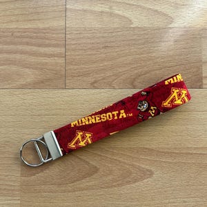 May include: Red and gold key chain with the University of Minnesota logo and the word "MINNESOTA" printed on it.