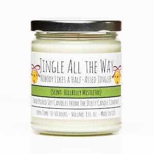 May include: A white soy candle in a glass jar with a silver lid. The label reads "Jingle All The Way Nobody Likes A Half-Assed Jingler (Scent: Hillbilly Mistletoe)" and "Hand Poured Soy Candles From The Dirty Candle Company Burn Time: 50-60 Hours - Volume: 8 fl. oz. - Made in USA".