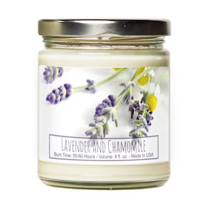 May include: A glass jar candle with a silver lid and a white label. The label has a floral design with lavender and chamomile flowers and the text "LAVENDER AND CHAMOMILE" with the details "Burn Time: 50-60 Hours - Volume: 8 fl. oz. - Made In USA".