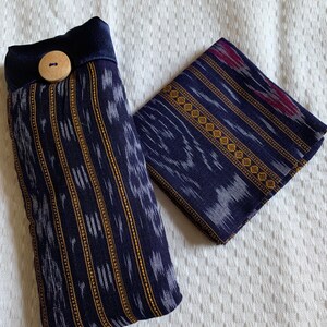 May include: Two blue and white fabric pouches with a gold and white geometric pattern. One pouch has a wooden button and a dark blue fabric flap.