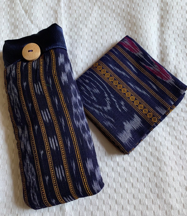 May include: Two blue and white fabric pouches with a gold and white geometric pattern. One pouch has a wooden button and a dark blue fabric flap.