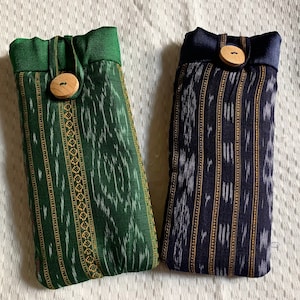 May include: Two fabric pouches with a striped pattern. One pouch is green with a brown button and the other is blue with a brown button.