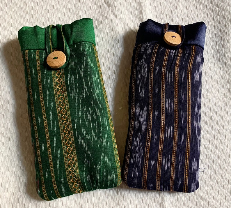 May include: Two fabric pouches with a striped pattern. One pouch is green with a brown button and the other is blue with a brown button.