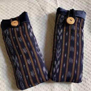 May include: Two blue and white striped fabric pouches with wooden buttons. The pouches have a drawstring closure.